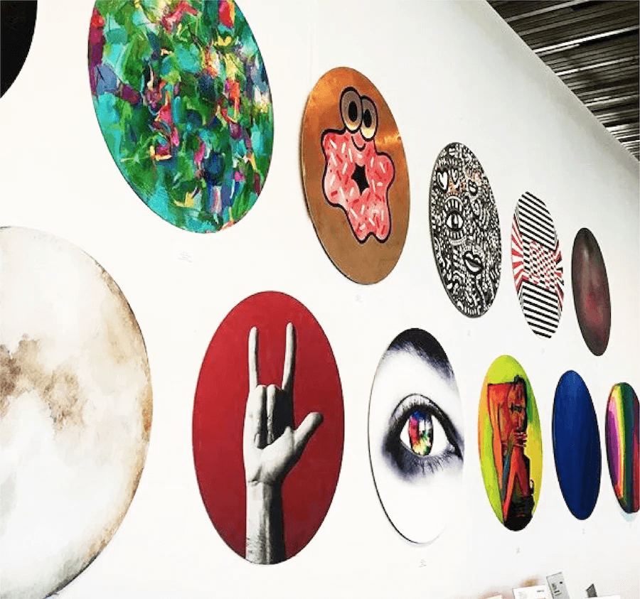 Collection of colorful oval artworks on a white wall
