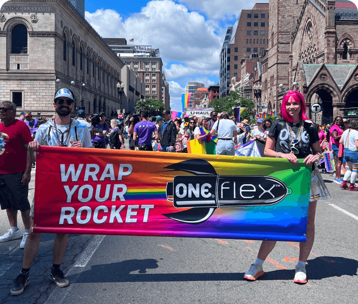 Two people holding a colorful banner with 'ONE Flex' branding on a street.