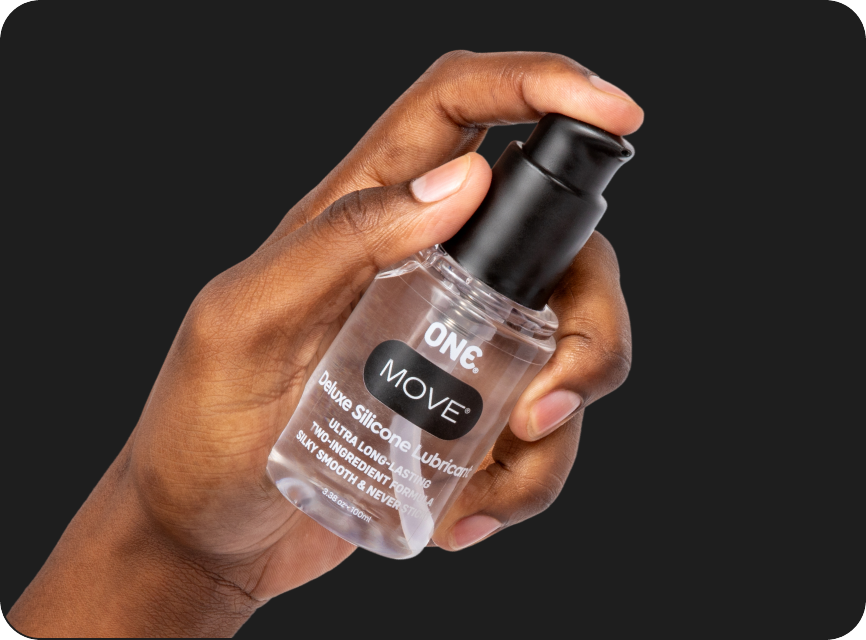 Hand holding a small bottle labeled 'ONE MOVE' against a black background