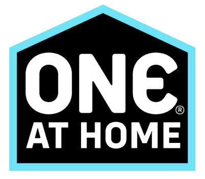Logo of 'ONE AT HOME' with a black house outline and blue border on a white background.